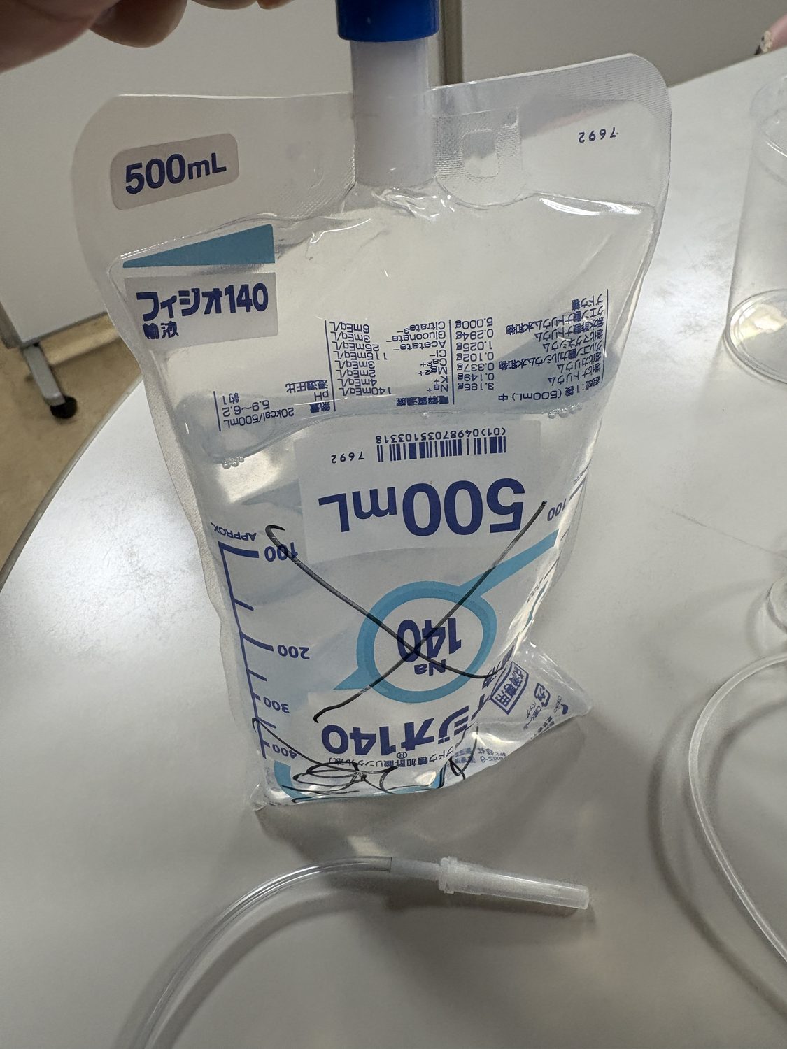 加圧バッグ用の生理食塩水にスパイクをまっすぐ刺し、バッグ内の空気を抜く準備段階